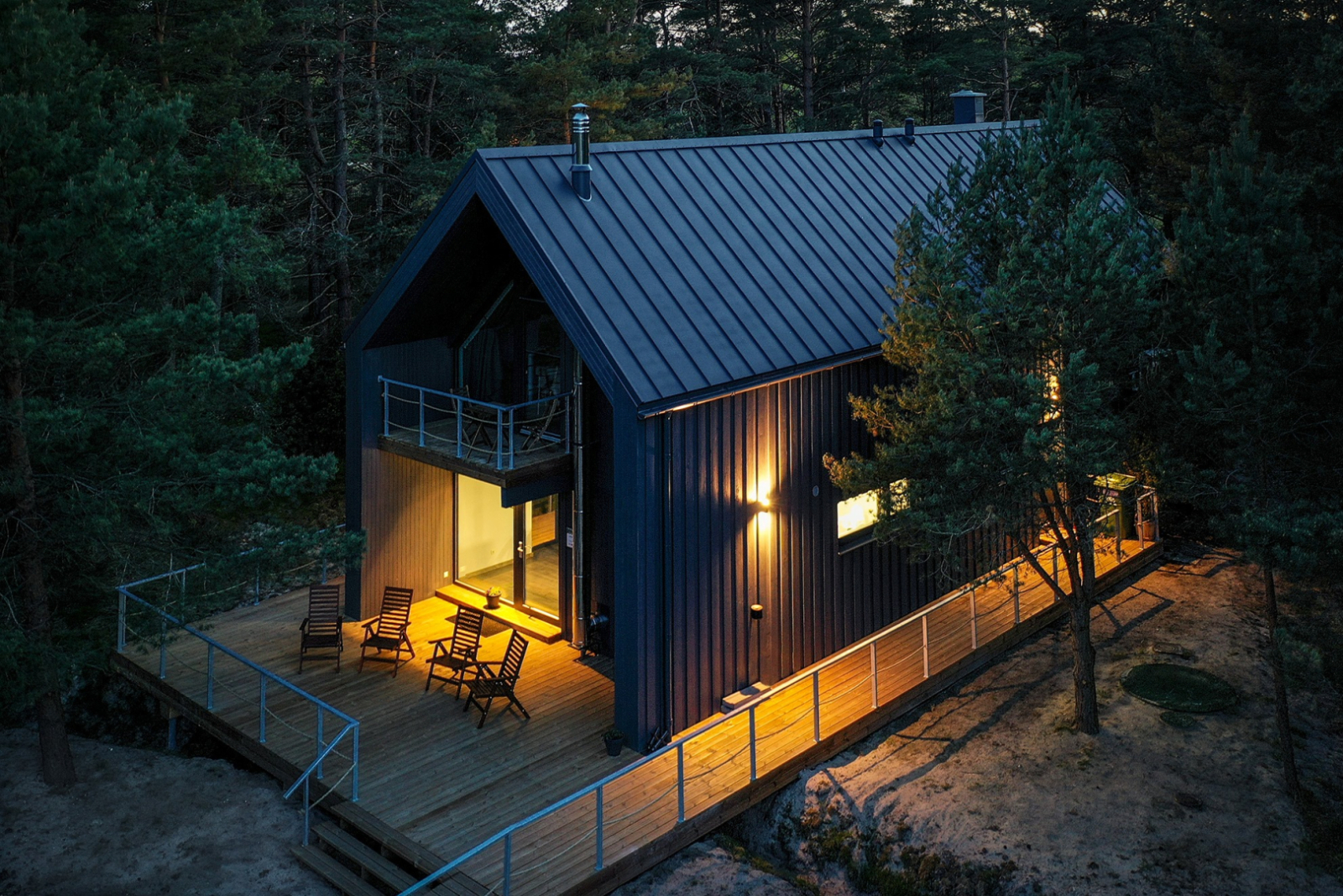 Brūna divstāvīga viesu māja ar gaismu logos no drona skata