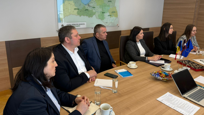 Sadarbības partneri no Moldovas maksājumu aģentūras sanāksmē pie galda.