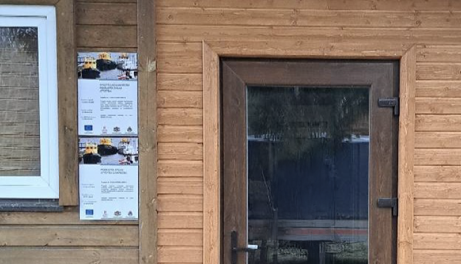 Durvis ar divām publicitātes plāksnēm pie tām