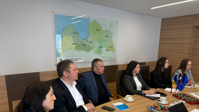 Sadarbības partneri no Moldovas maksājumu aģentūras sanāksmē pie galda.