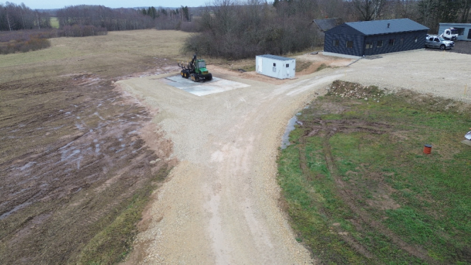 No druona šembu laukums ar melnu garāžu labajā augšējā stūrī un zaļu traktoru