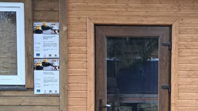 Durvis ar divām publicitātes plāksnēm pie tām