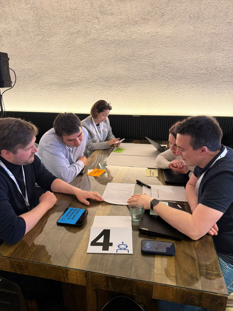 Konferences dalībnieki apspriežas pie galda