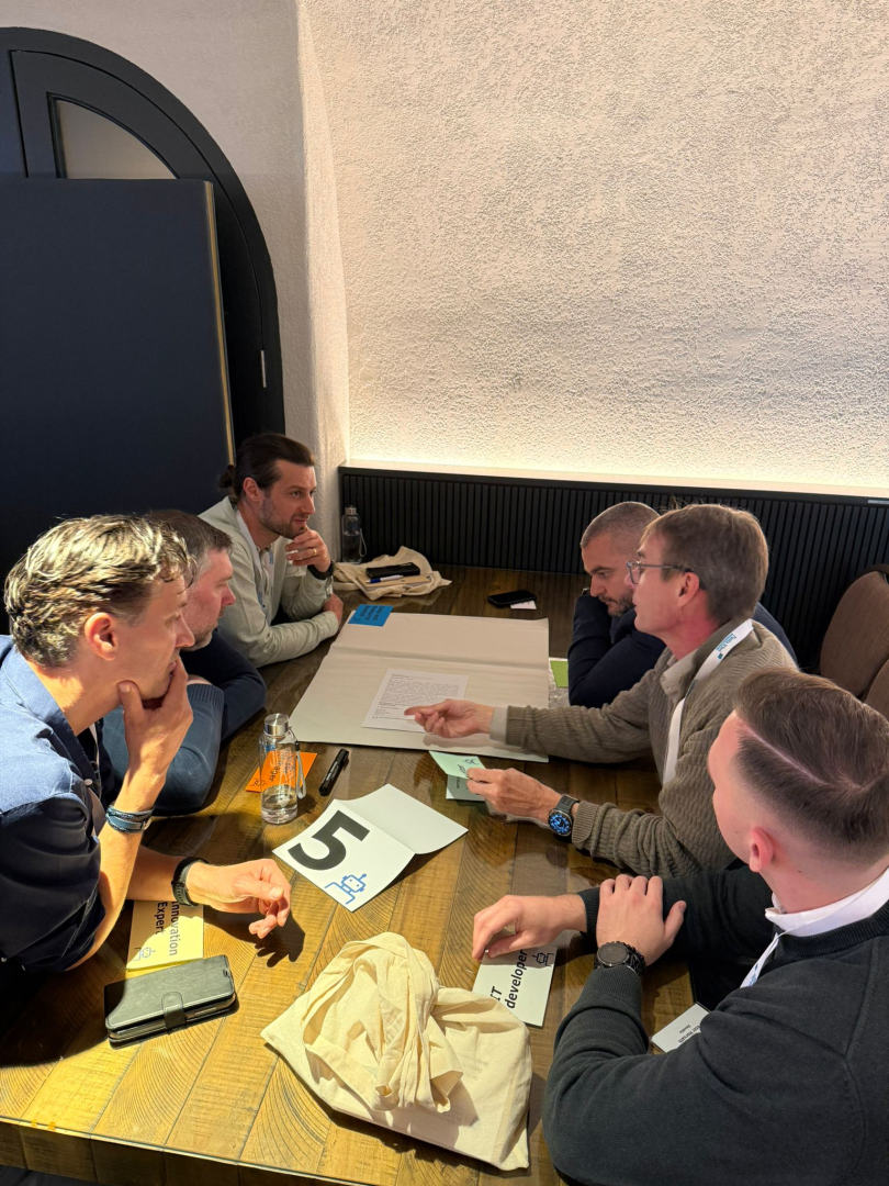 Konferences dalībnieki apspriežas pie galda