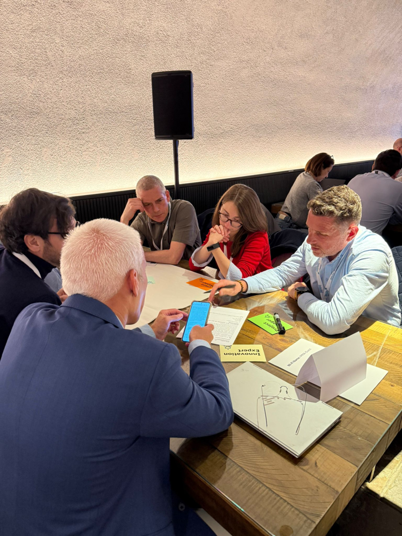 Konferences dalībnieki apspriežas pie galda