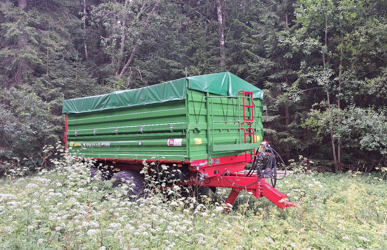 zaļa piekabe stāv augstā zālē