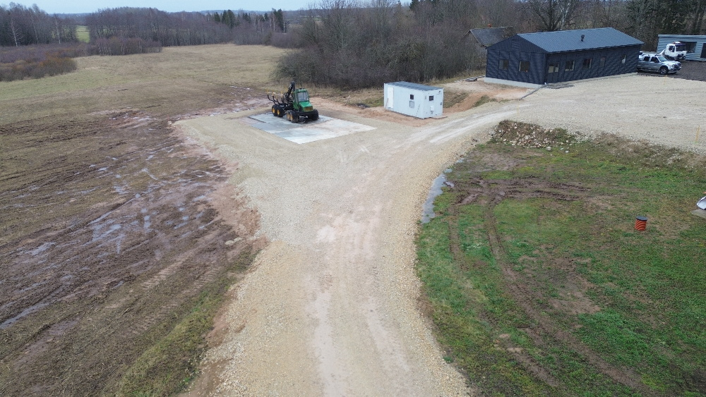 No druona šembu laukums ar melnu garāžu labajā augšējā stūrī un zaļu traktoru