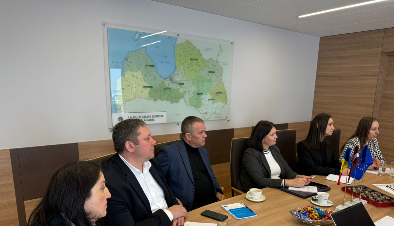 Sadarbības partneri no Moldovas maksājumu aģentūras sanāksmē pie galda.