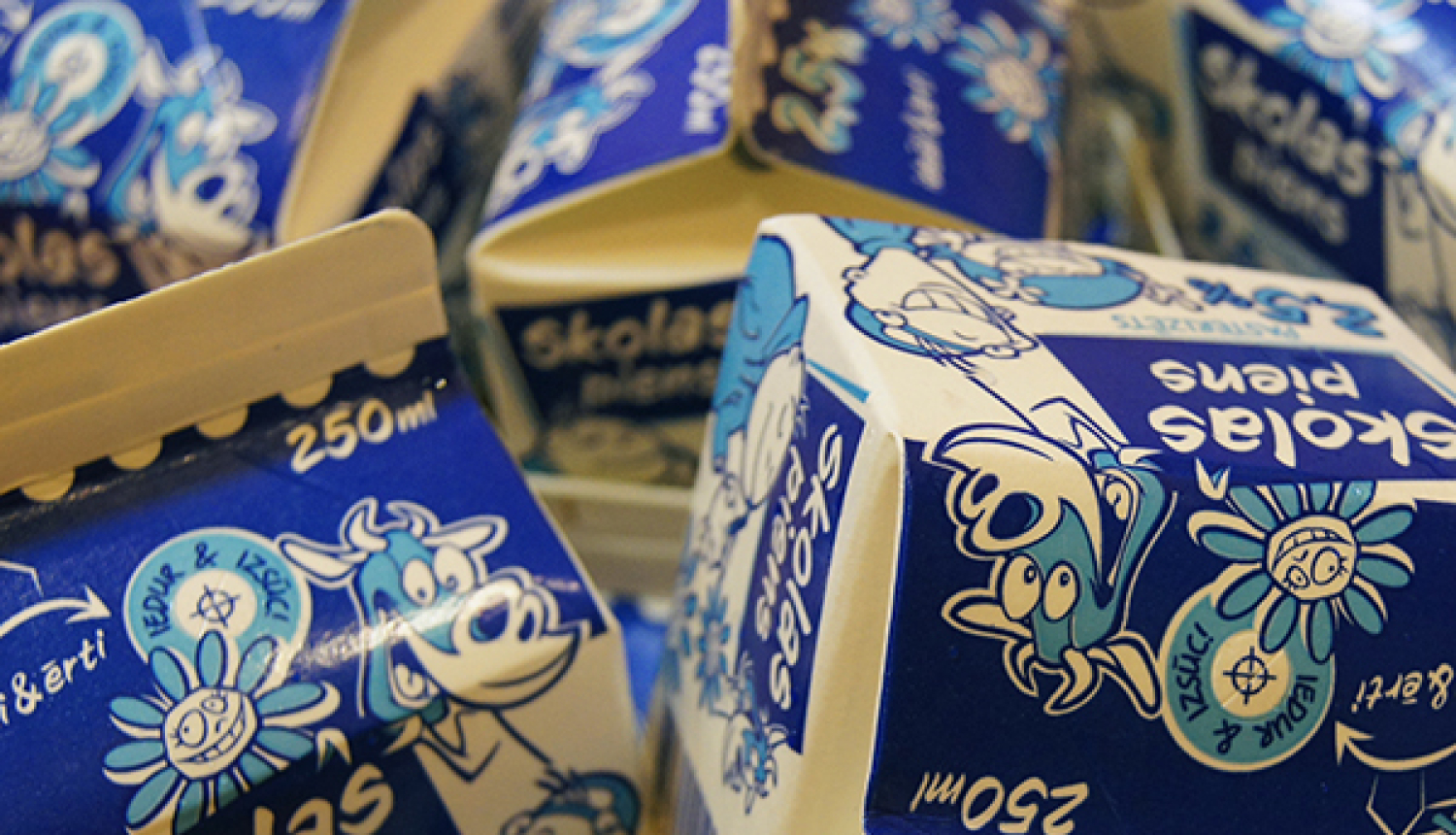 Zilās un baltās krāsās veidotas "Skolas piens" 250 ml piena pakas ar dzīvnieku attēliem. 