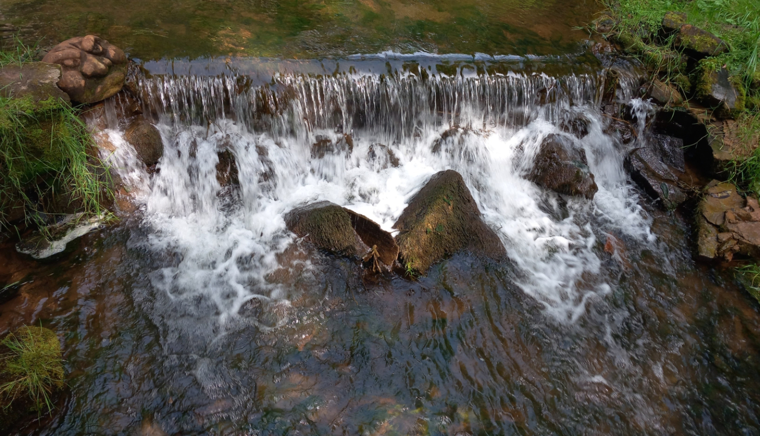 šaurs ūdenskritums uz mazas upītes no augšas