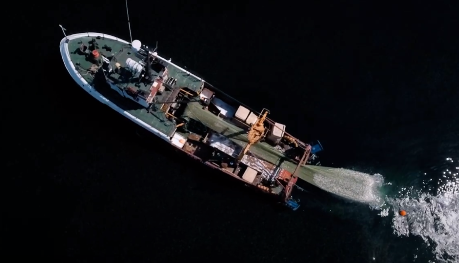 Zvejas laiva no augšas ar tīklu zvejo jūrā