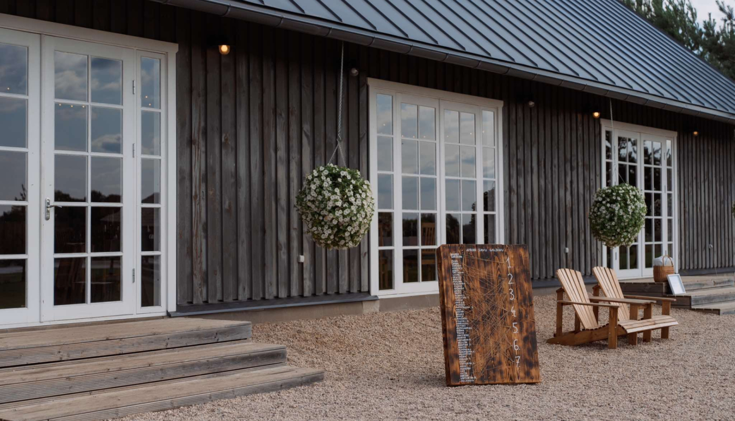 Ēkas ieeja ar 3 baltiem logiem/durvīm