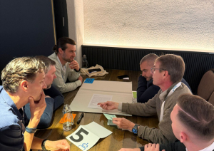 Konferences dalībnieki apspriežas pie galda