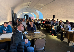 Konferences dalībnieki apspriežas pie galda