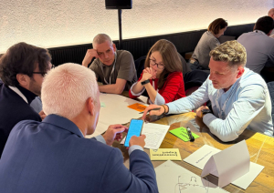 Konferences dalībnieki apspriežas pie galda